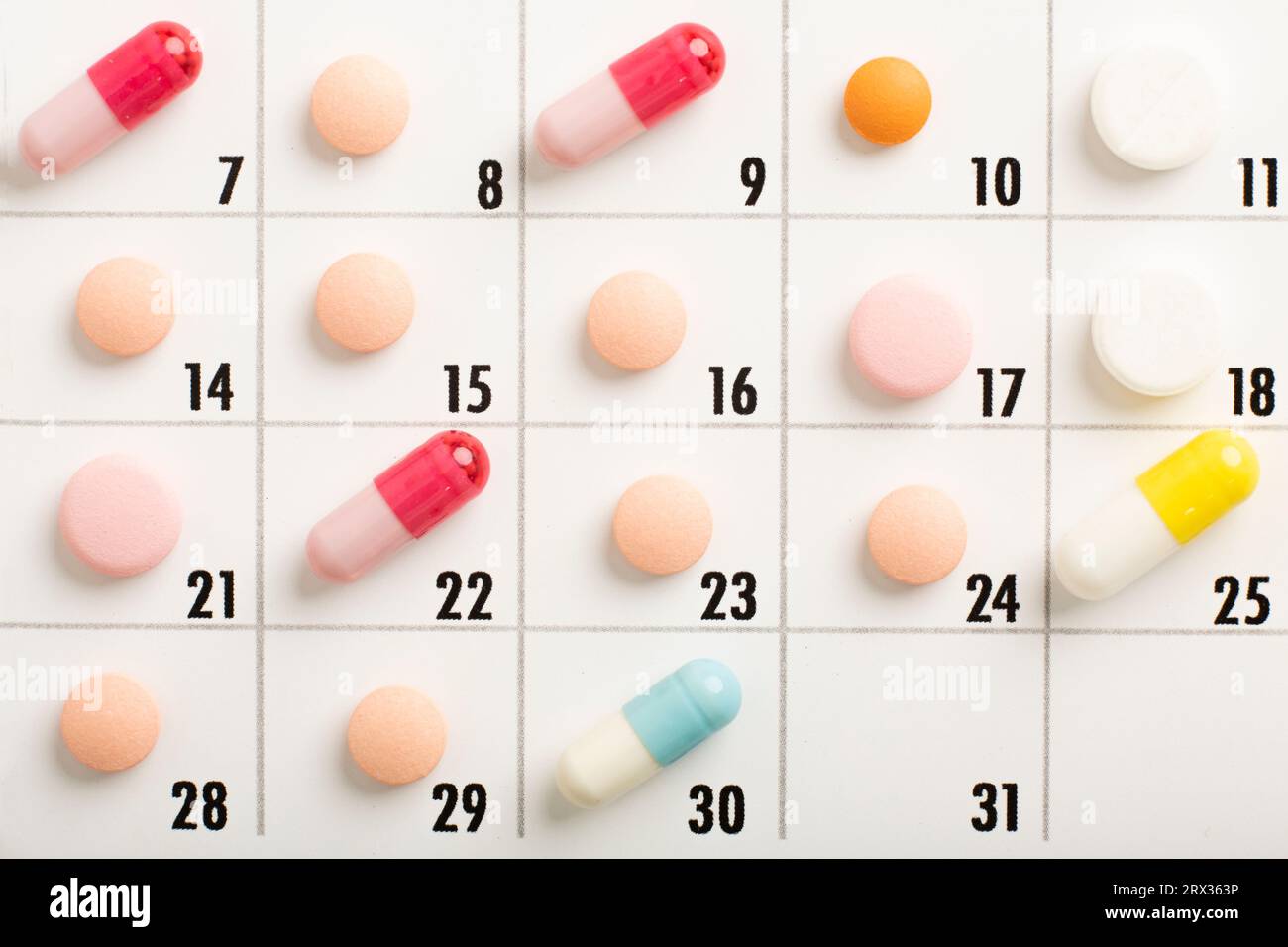 pills are of different color on the calendar. Schedule medication. Focus on a light green pill. High quality photo Stock Photo