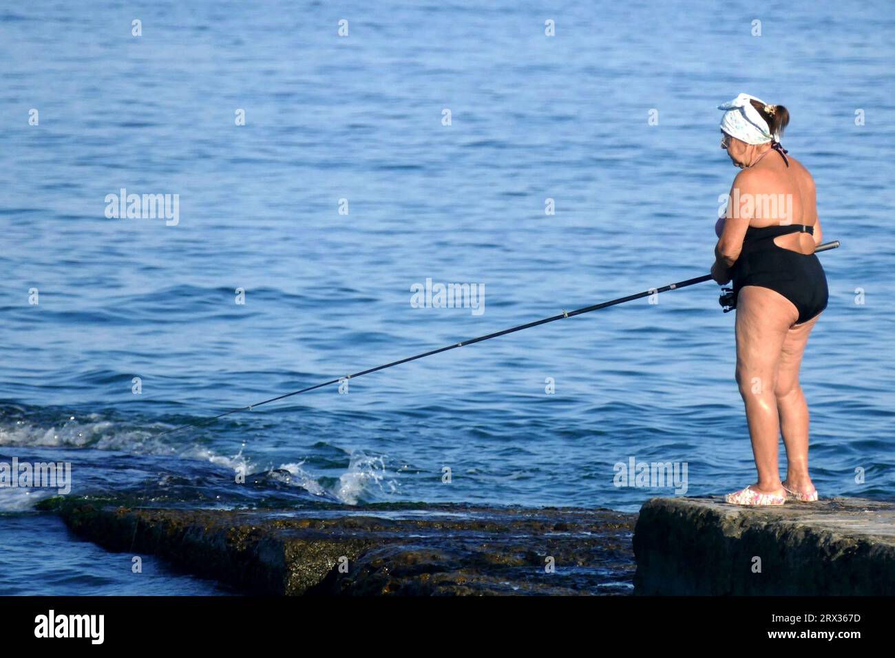 Non Exclusive: ODESA, UKRAINE - SEPTEMBER 17, 2023 - A woman fishes on the pier at the Lanzheron beach, Odesa, southern Ukraine. Stock Photo
