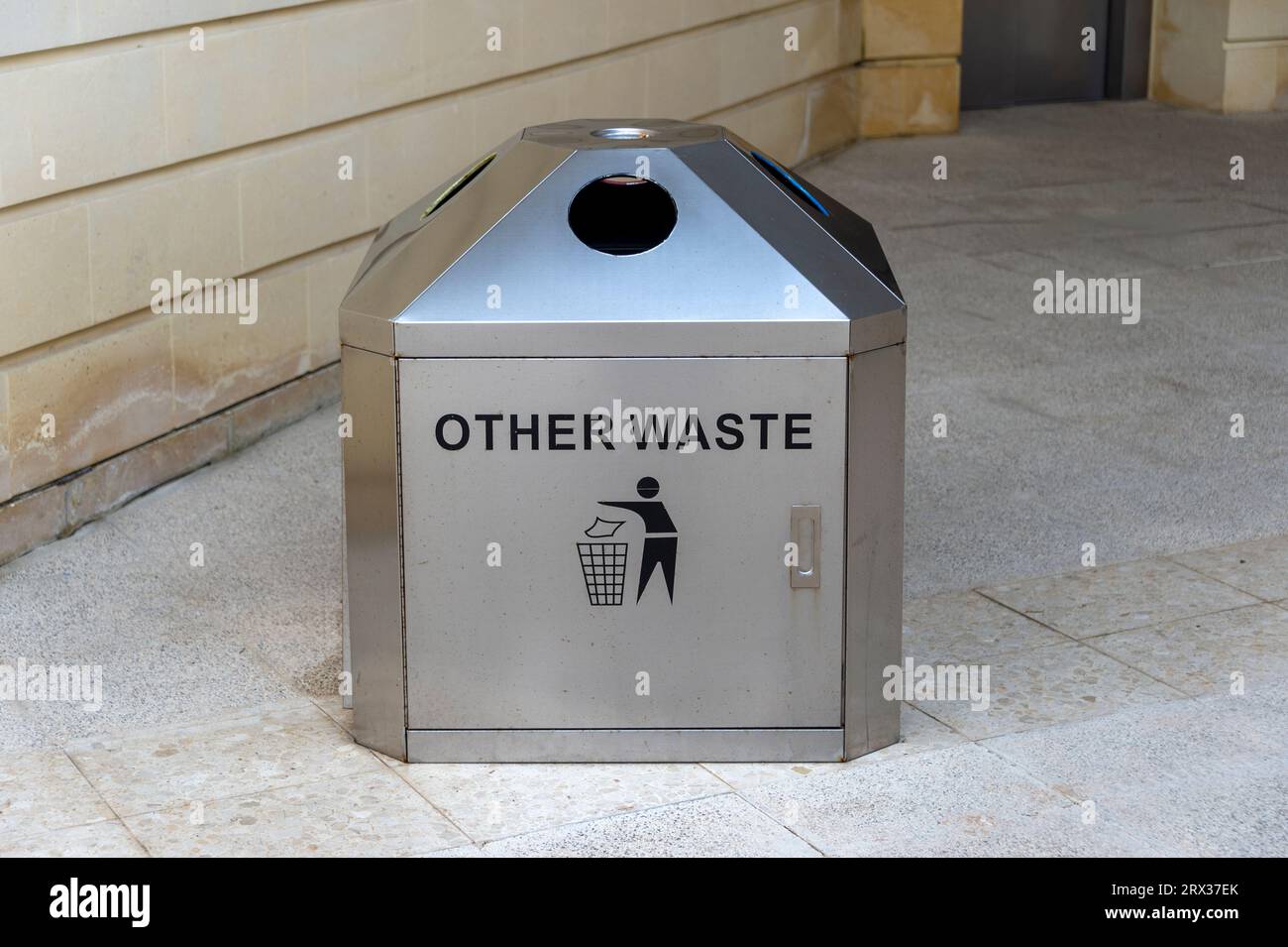 Metal trash can in the street with 'other waste' written on it. Stock Photo