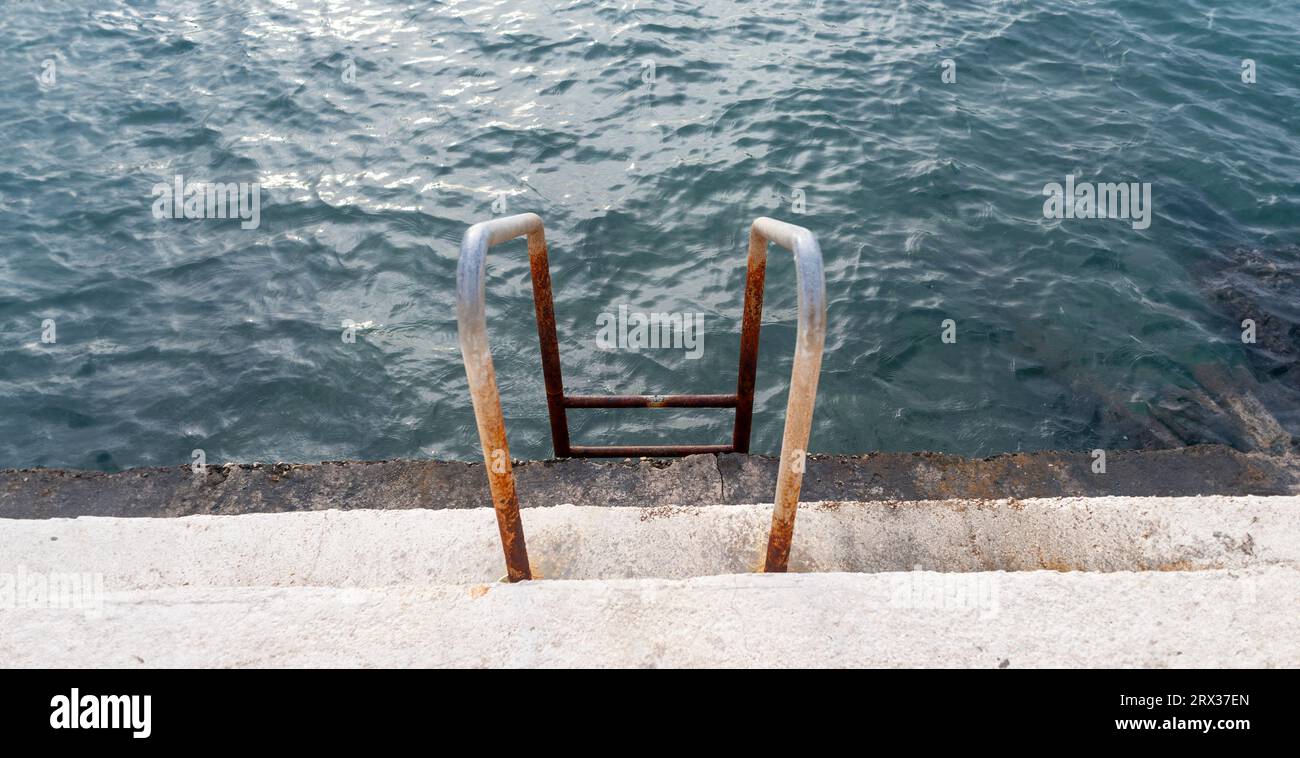Metal ladder into the sea for swimming Stock Photo