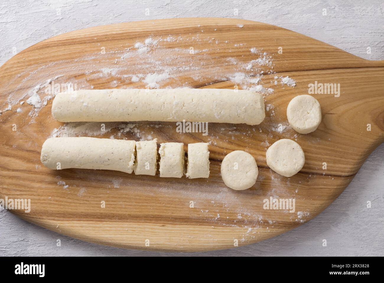 Wooden board with raw cottage cheese gnocchi on a light gray background, top view. Cooking stage Stock Photo