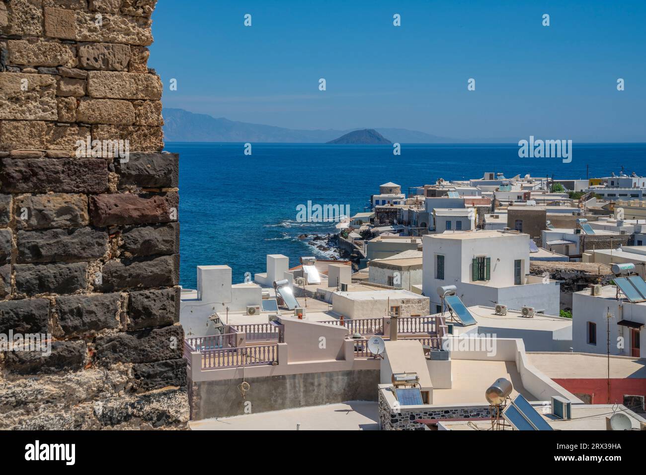 View of sea and whitewashed buildings and rooftops of Mandraki, Mandraki, Nisyros, Dodecanese, Greek Islands, Greece, Europe Stock Photo