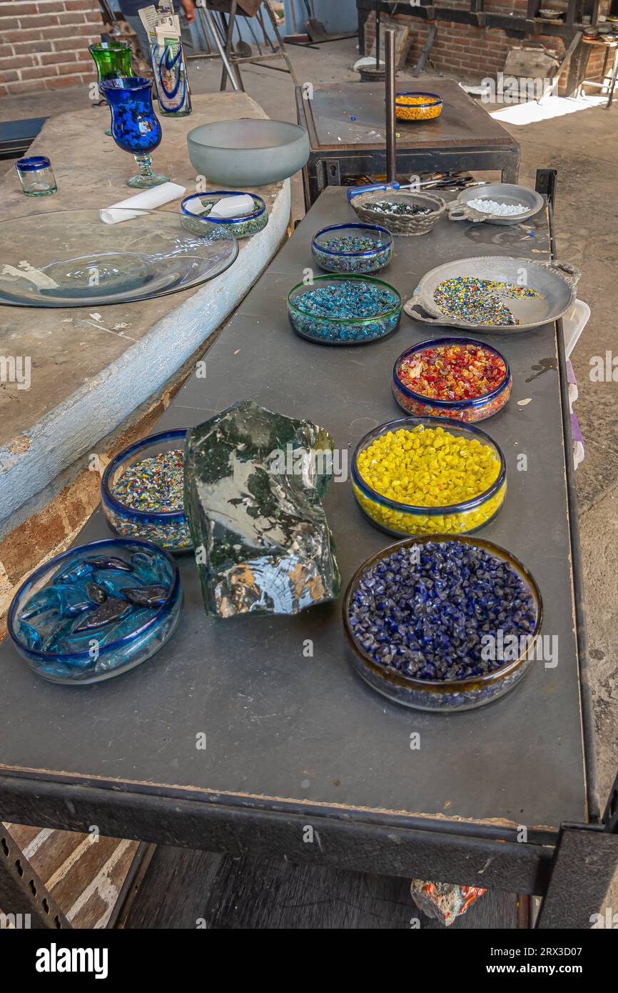 Mexico, Cabo San Lucas - July 16, 2023: La Fabrica de Vidrio Soplado. Hand blown artistic glass factory. Dishes filled with different color pellets se Stock Photo