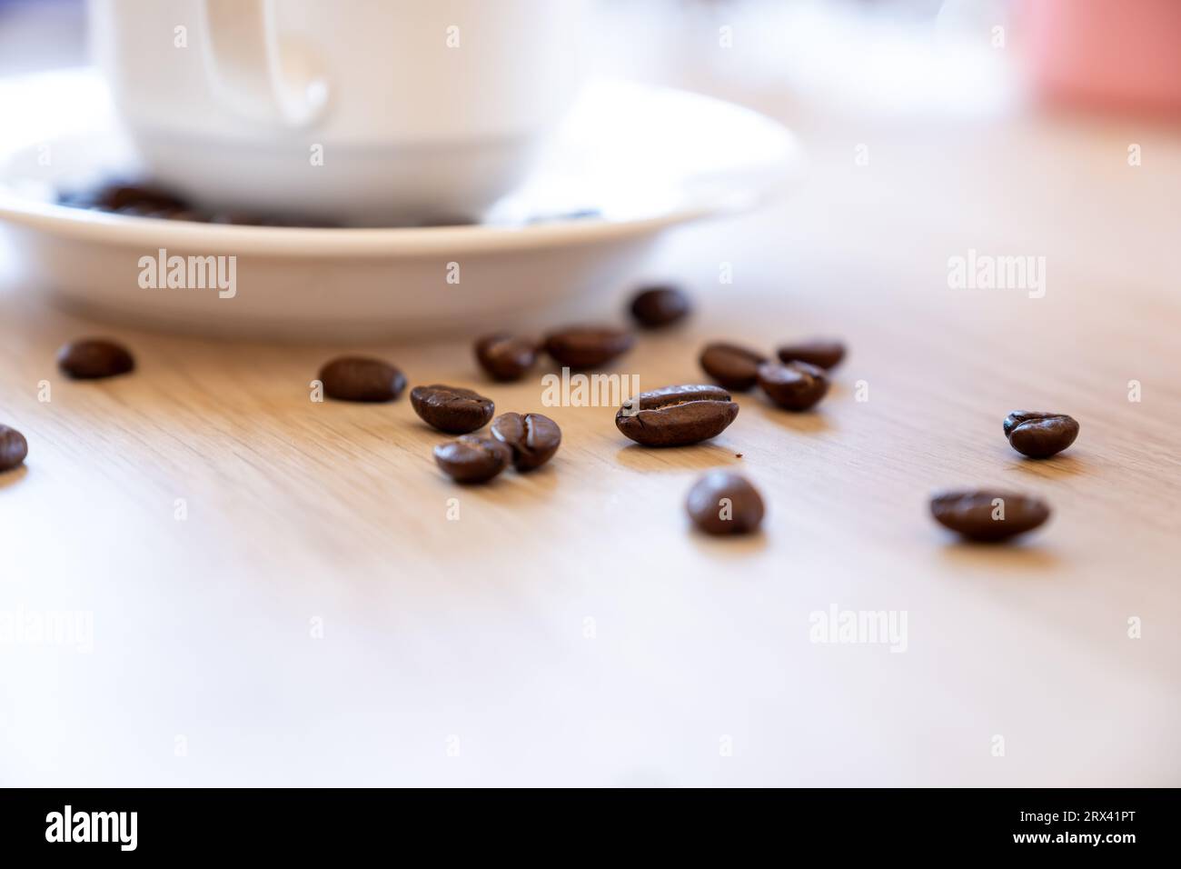 Cup of coffee that full of coffee beans on wooden background with rim light Stock Photo