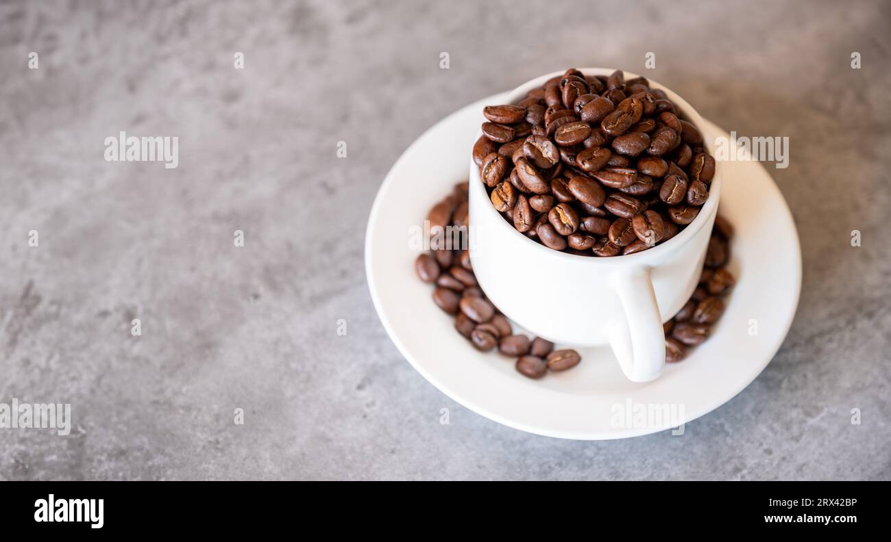 cup of coffee that full of coffee beans on grey living room table Stock Photo
