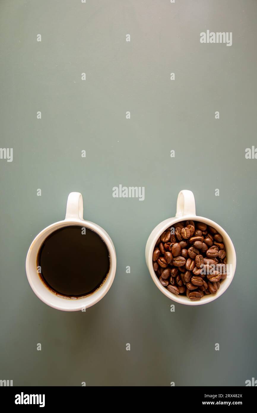 Coffee cups on green background  full of coffee beans and drink Stock Photo