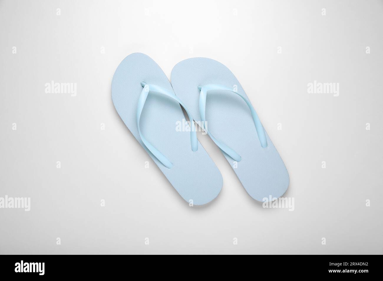 Light blue flip flops on white background, top view Stock Photo - Alamy