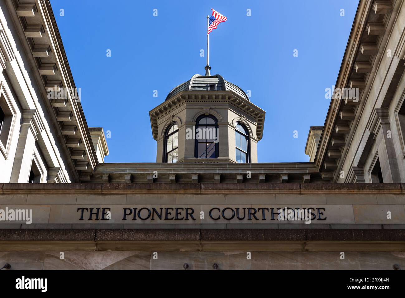 American flag above the Pioneer Courthouse building in downtown Portland Oregon Stock Photo