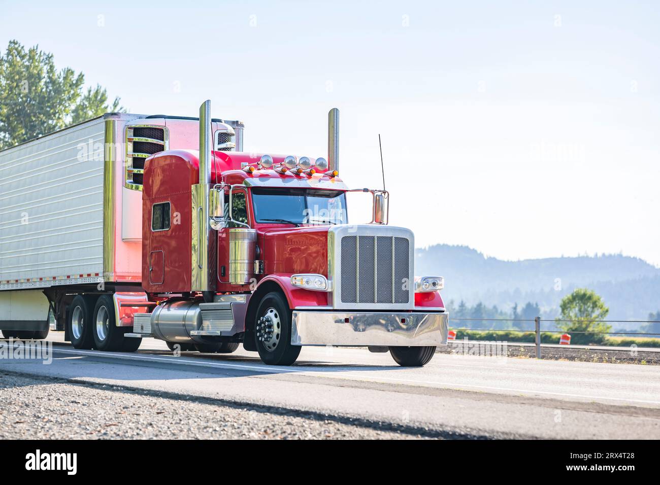 Industrial long hauler carrier red classic big rig semi truck tractor with extended cab for truck driver rest  transporting cargo in refrigerator semi Stock Photo