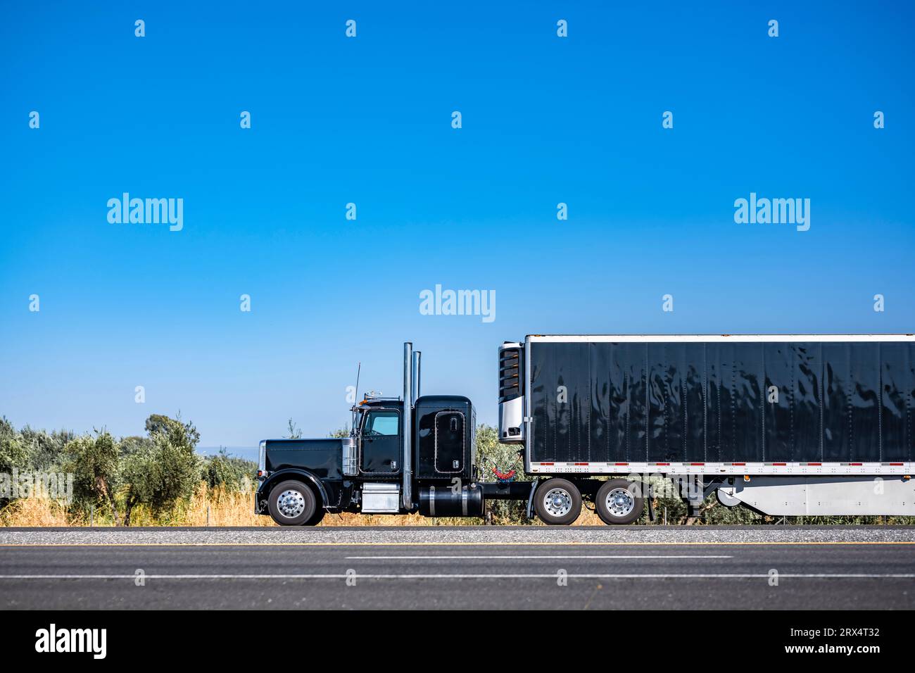 Industrial long hauler carrier black big rig semi truck tractor with extended cab for truck driver rest  transporting cargo in refrigerator semi trail Stock Photo