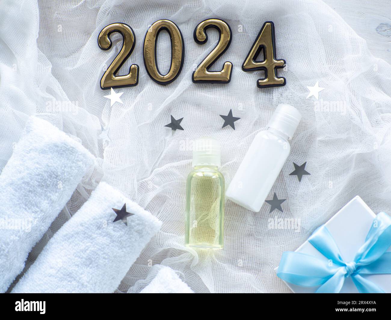 Christmas composition with 2024, towels, giftbox and body care products
