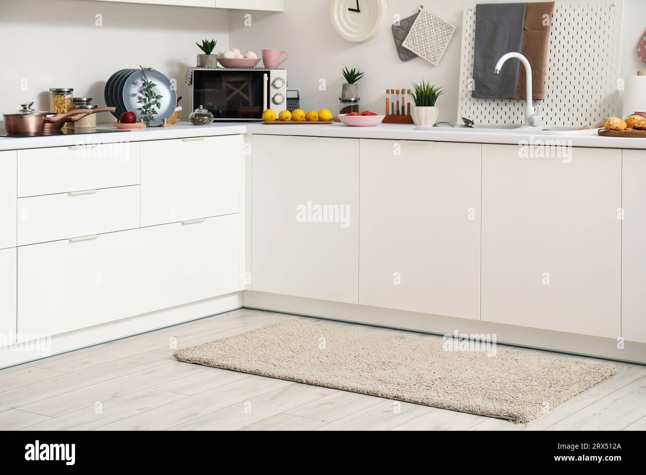 Interior of modern kitchen with stylish rug and white counters Stock ...