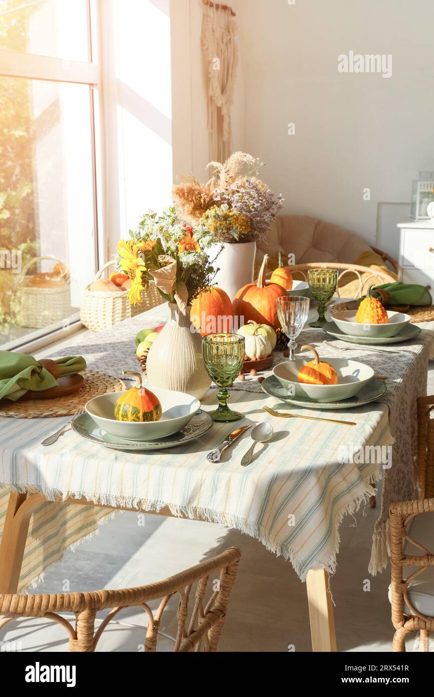 Dining table with autumn setting and pumpkins in room Stock Photo - Alamy
