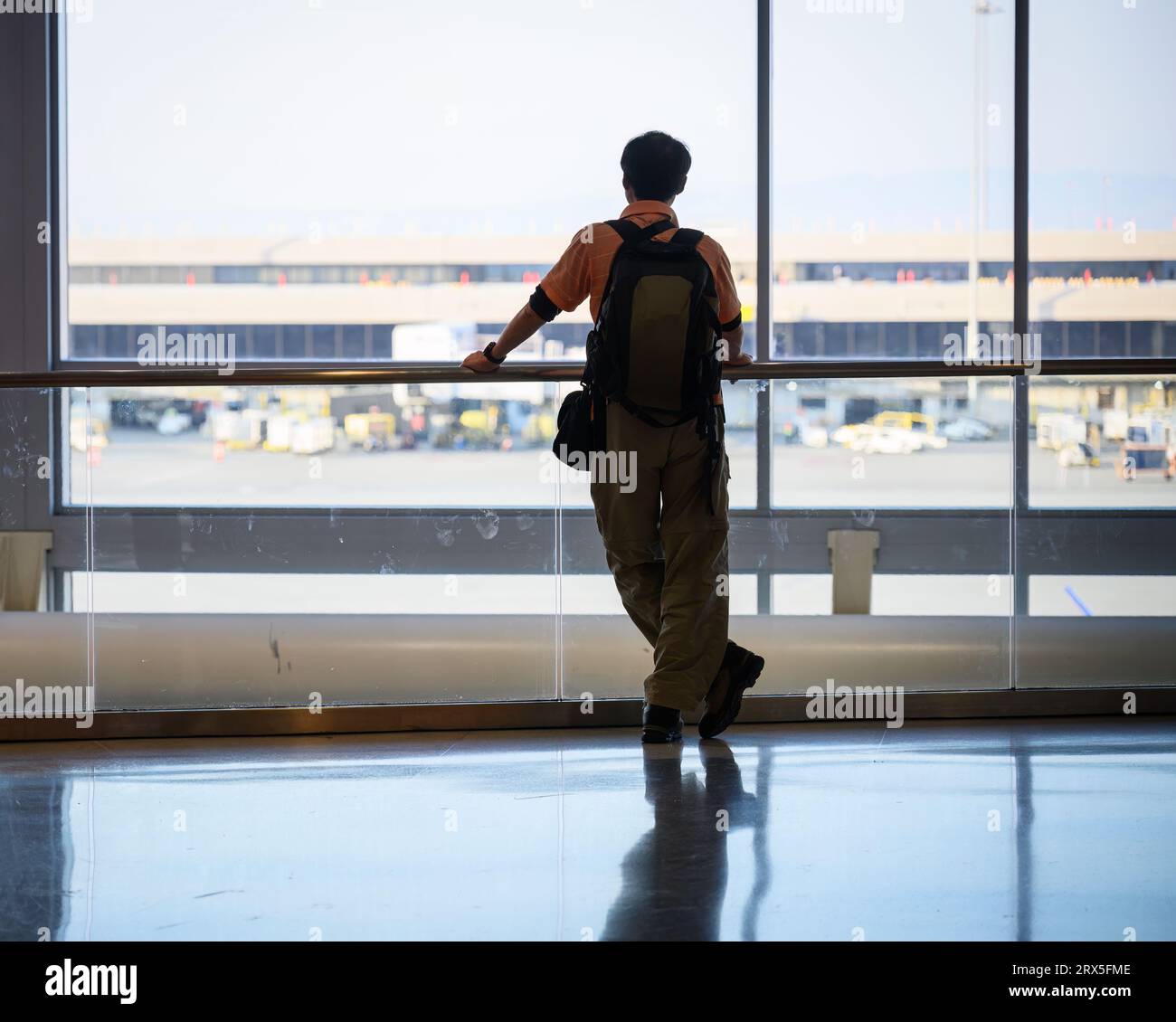 Man looking out of the window at the airport. Stock Photo