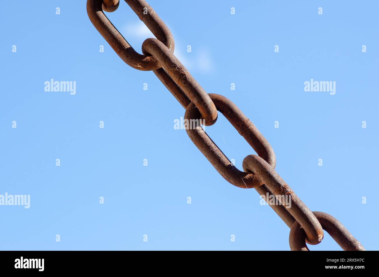 rusty chains brick background, a symbol of strength and oppression, used in industry in crowbars as well as for slavery. very large chain links. Stock Photo