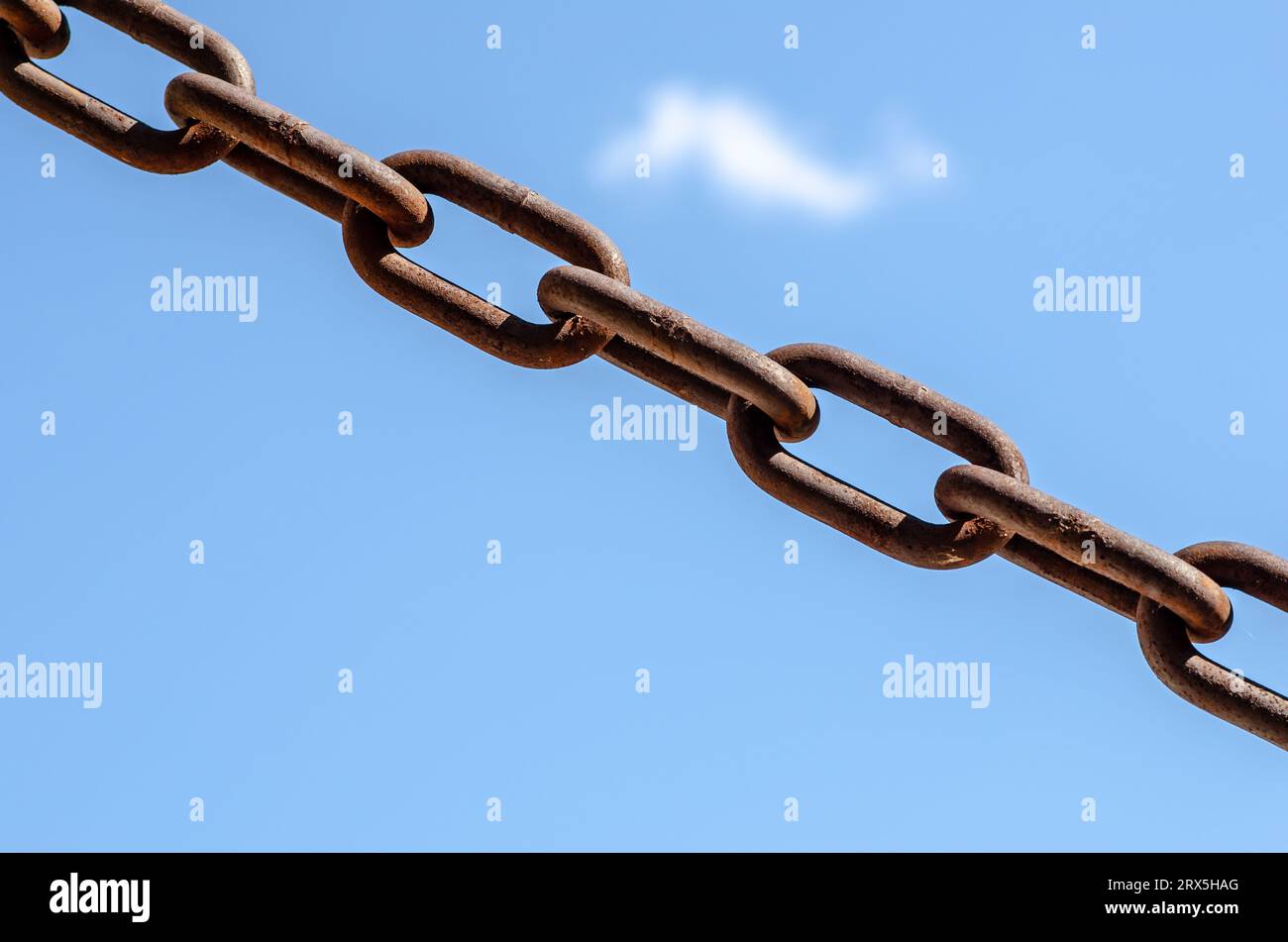 rusty chains, sky background, a symbol of strength and oppression, used in industry in crowbars as well as for slavery. very large chain links. Stock Photo