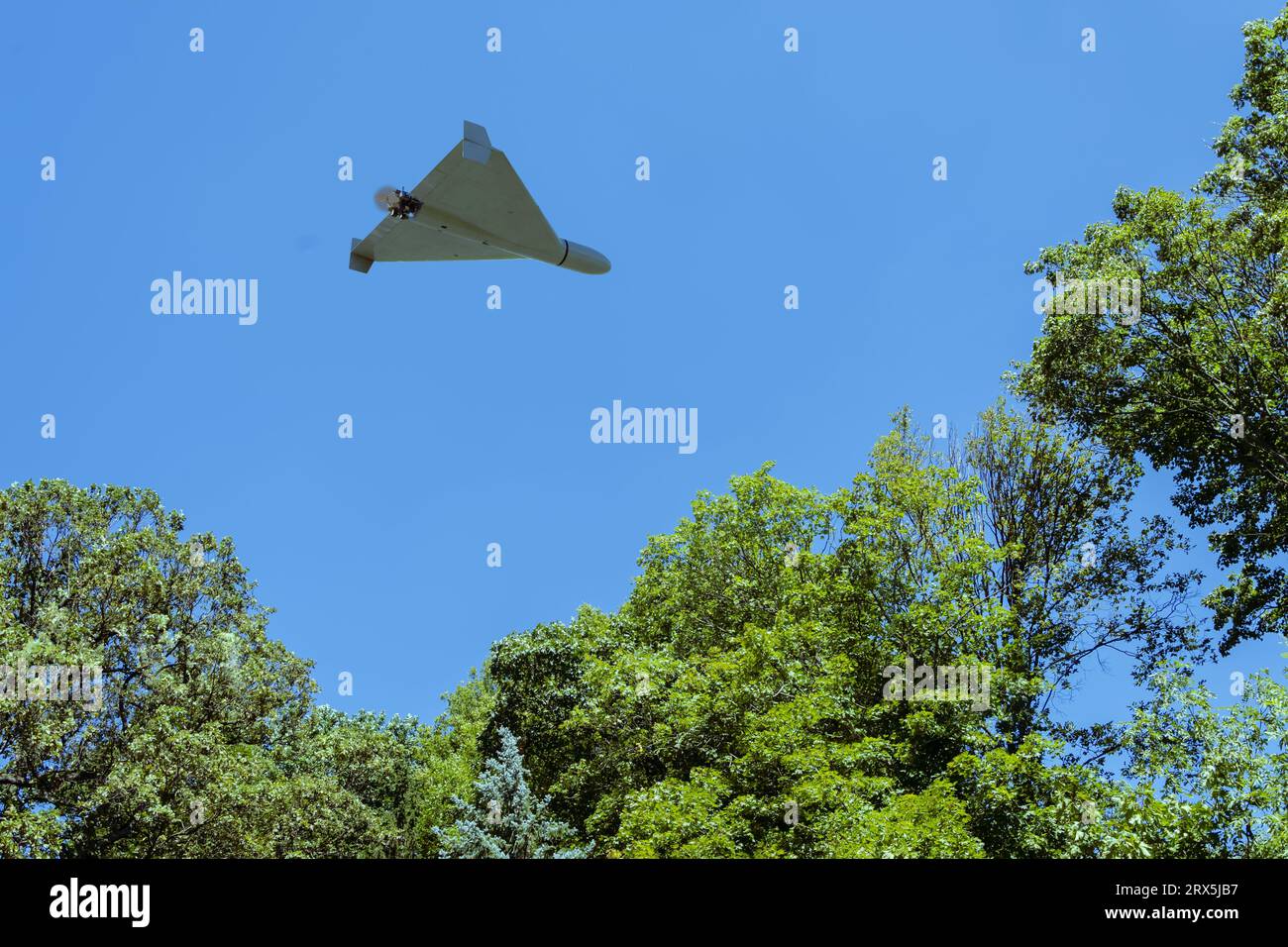 Shahed combat drone flying in the background of city fan and sky , view from below, drone attack, war Stock Photo