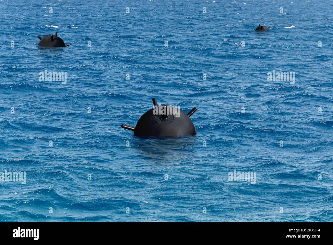 Military sea mines in the sea, MINE FENCE, anti-ship mines. Concept: war in Ukraine, mine barrages, danger in water. Stock Photo