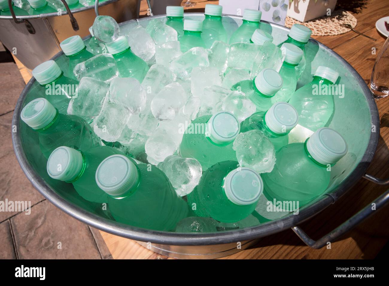 Small water bottles cooling in a zinc washbowl. Overhead view Stock
