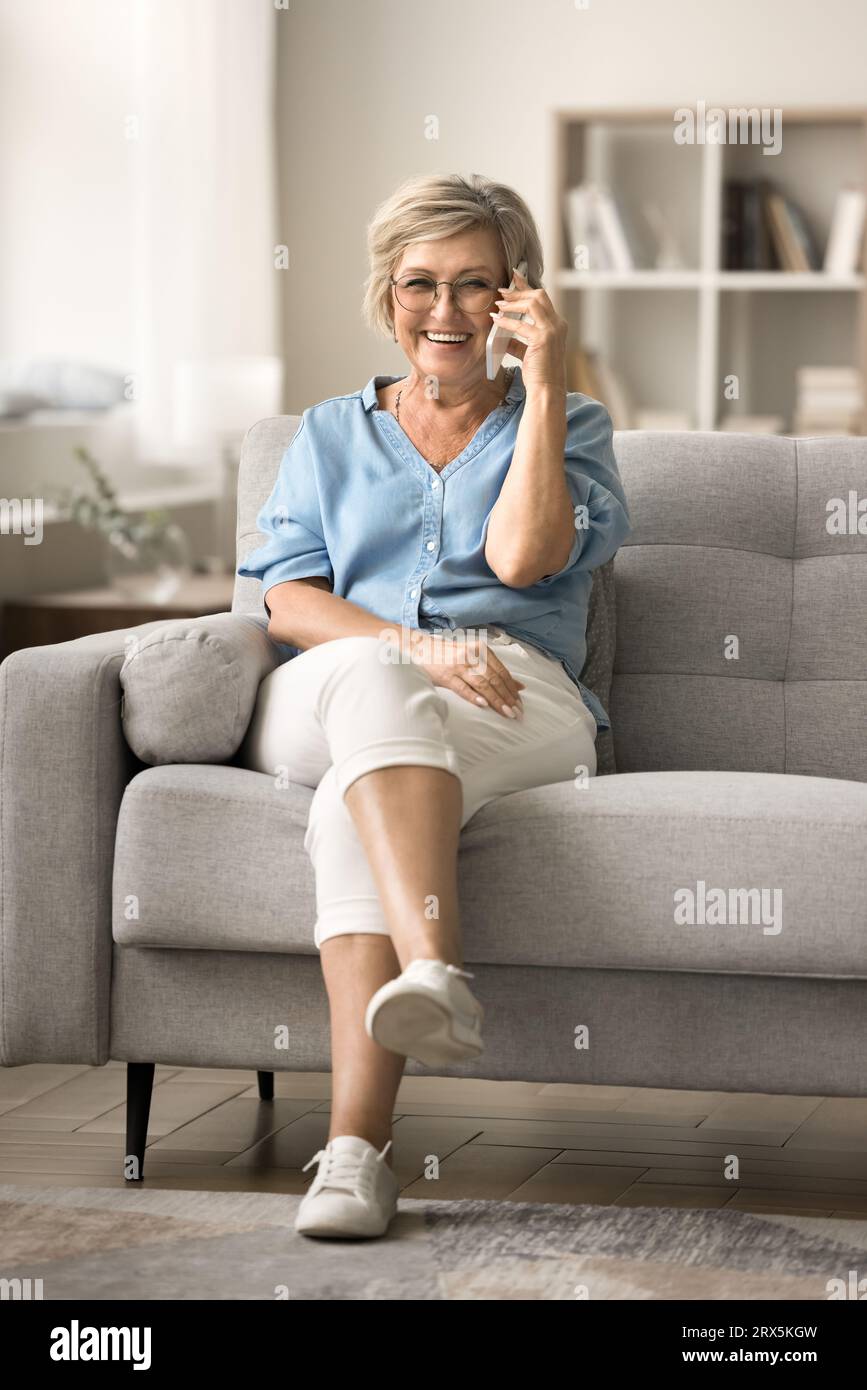 Joyful elder mature woman enjoying funny telephone conversation Stock Photo
