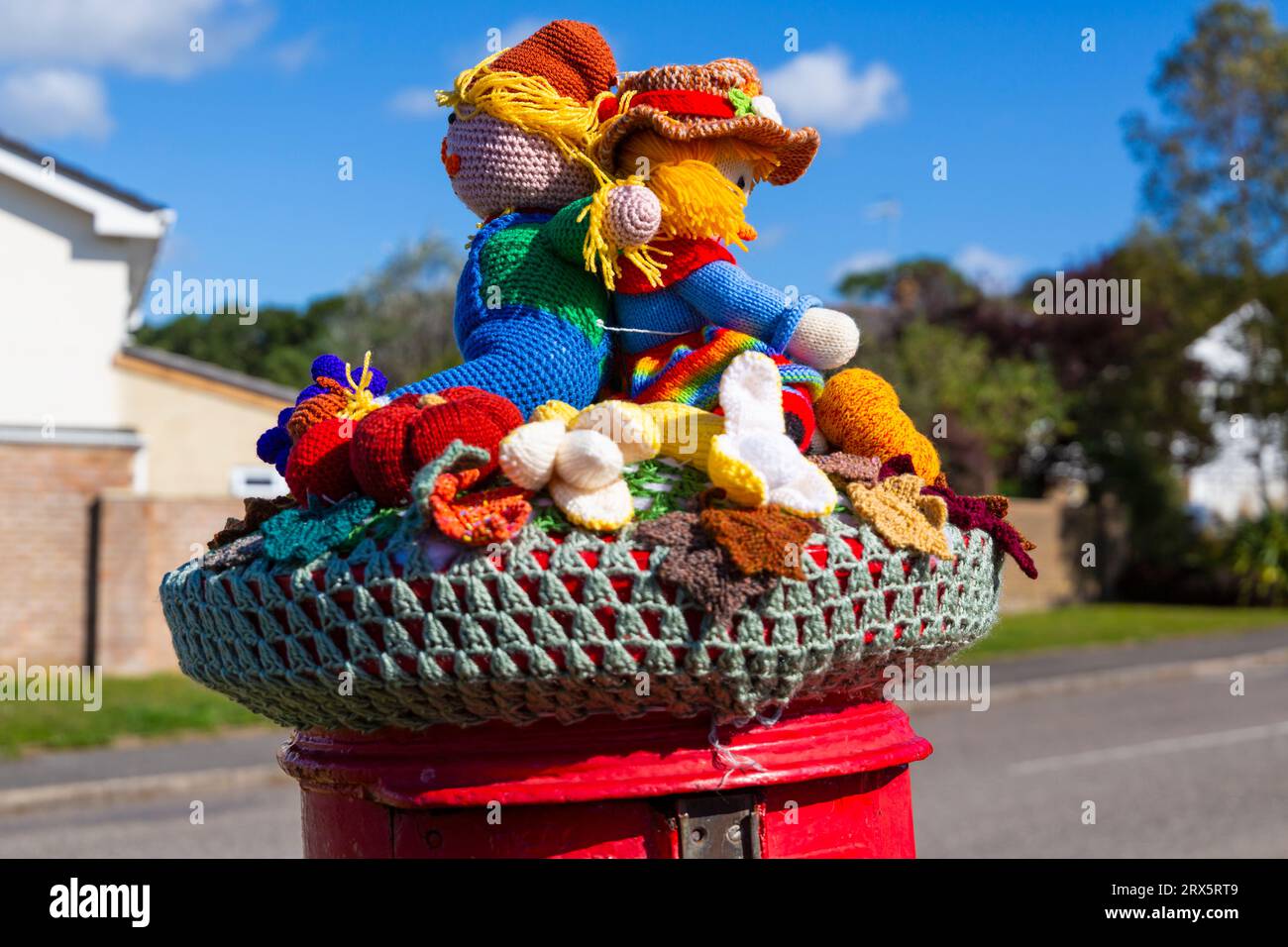 Poole, Dorset, UK. 23rd September 2023. UK Weather: Sunshine as a knitted crocheted postbox topper appears on a red post box in Poole, Dorset with a Harvest Festival theme, a celebration of the harvest and food grown, to celebrate when crops have been gathered and people can reflect and show gratitude for the food they have. Credit: Carolyn Jenkins/Alamy Live News Stock Photo