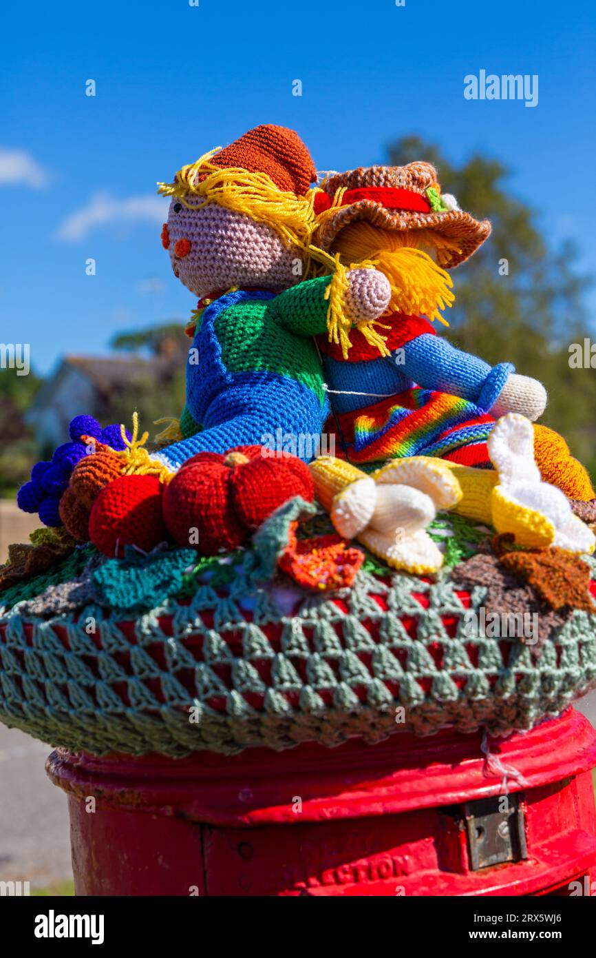 Poole, Dorset, UK. 23rd September 2023. UK Weather: Sunshine as a knitted crocheted postbox topper appears on a red post box in Poole, Dorset with a Harvest Festival theme, a celebration of the harvest and food grown, to celebrate when crops have been gathered and people can reflect and show gratitude for the food they have. Credit: Carolyn Jenkins/Alamy Live News Stock Photo