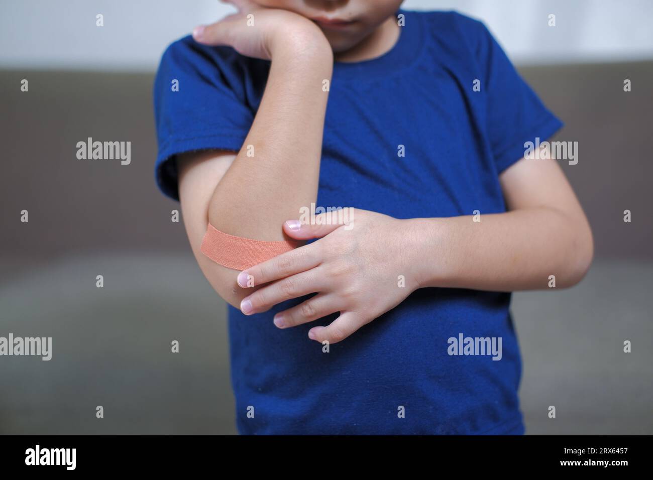 A boy hurts his arm, holding his bandaged arm Stock Photo Alamy