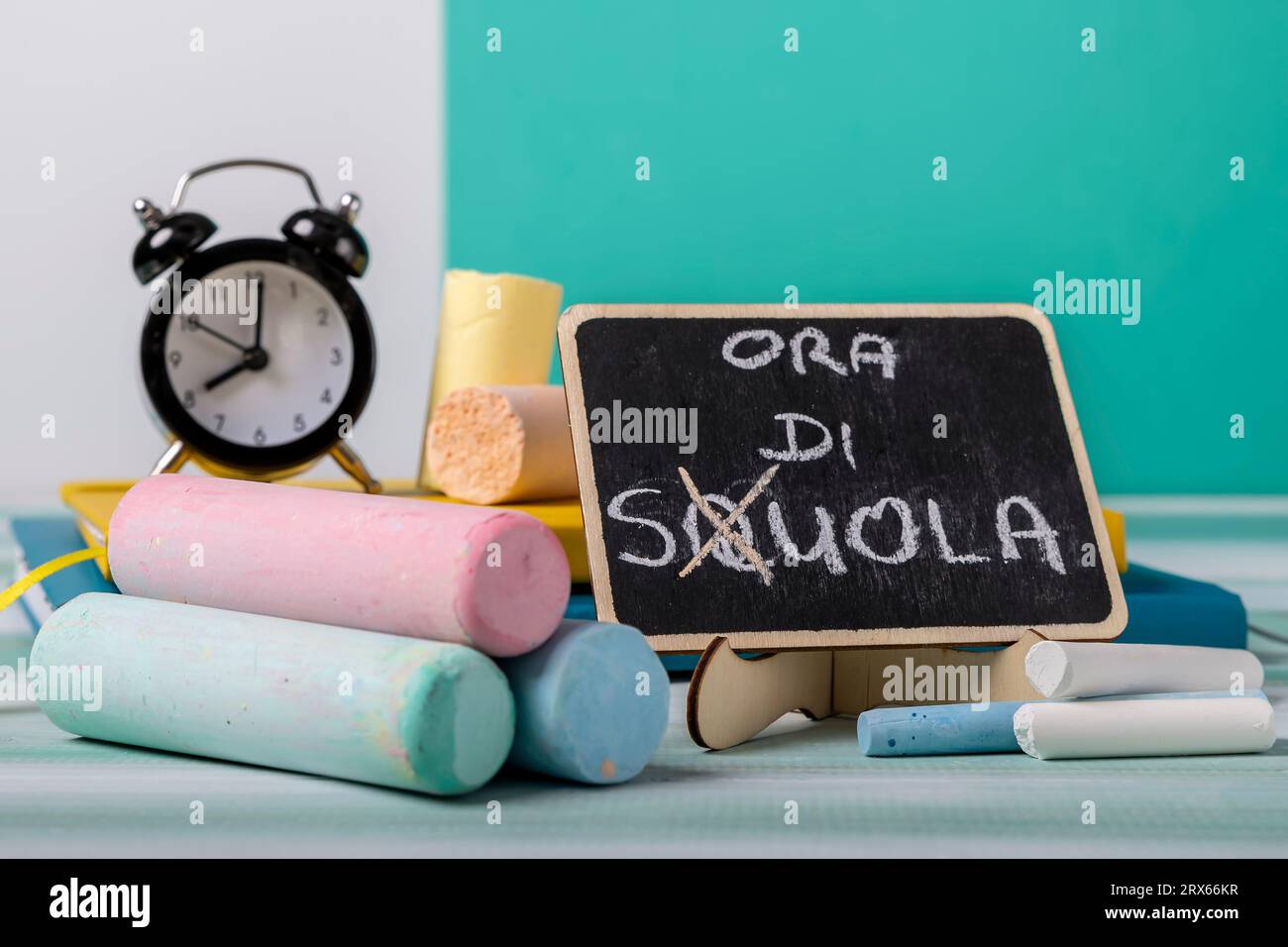 Chalks of various sizes and colors with a blackboard next to it with