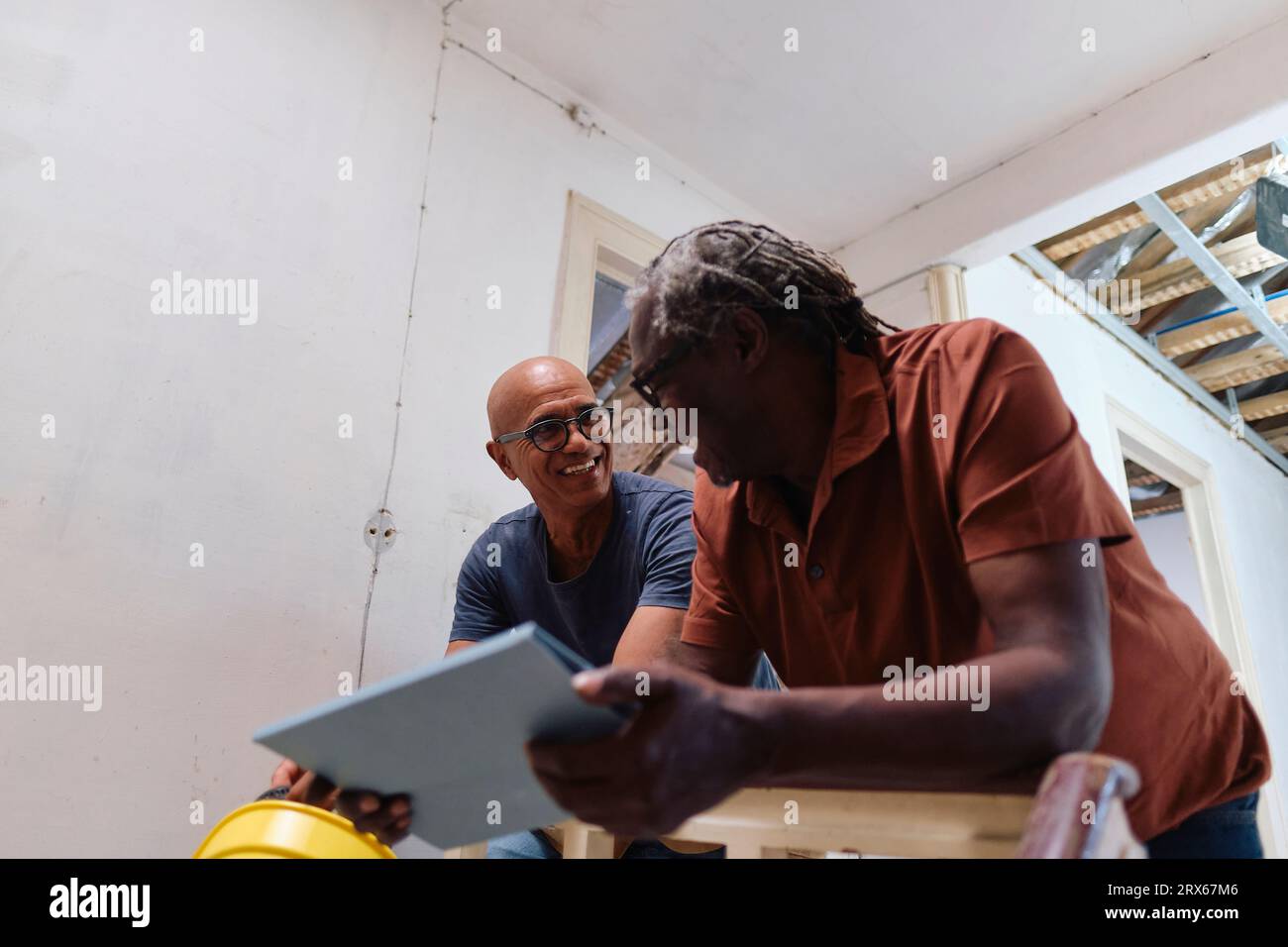 Happy architect and builder having discussion together at site Stock Photo