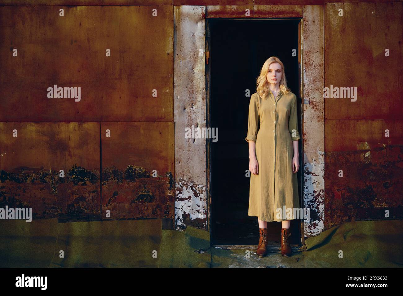 Contemplative young woman standing in doorway Stock Photo - Alamy