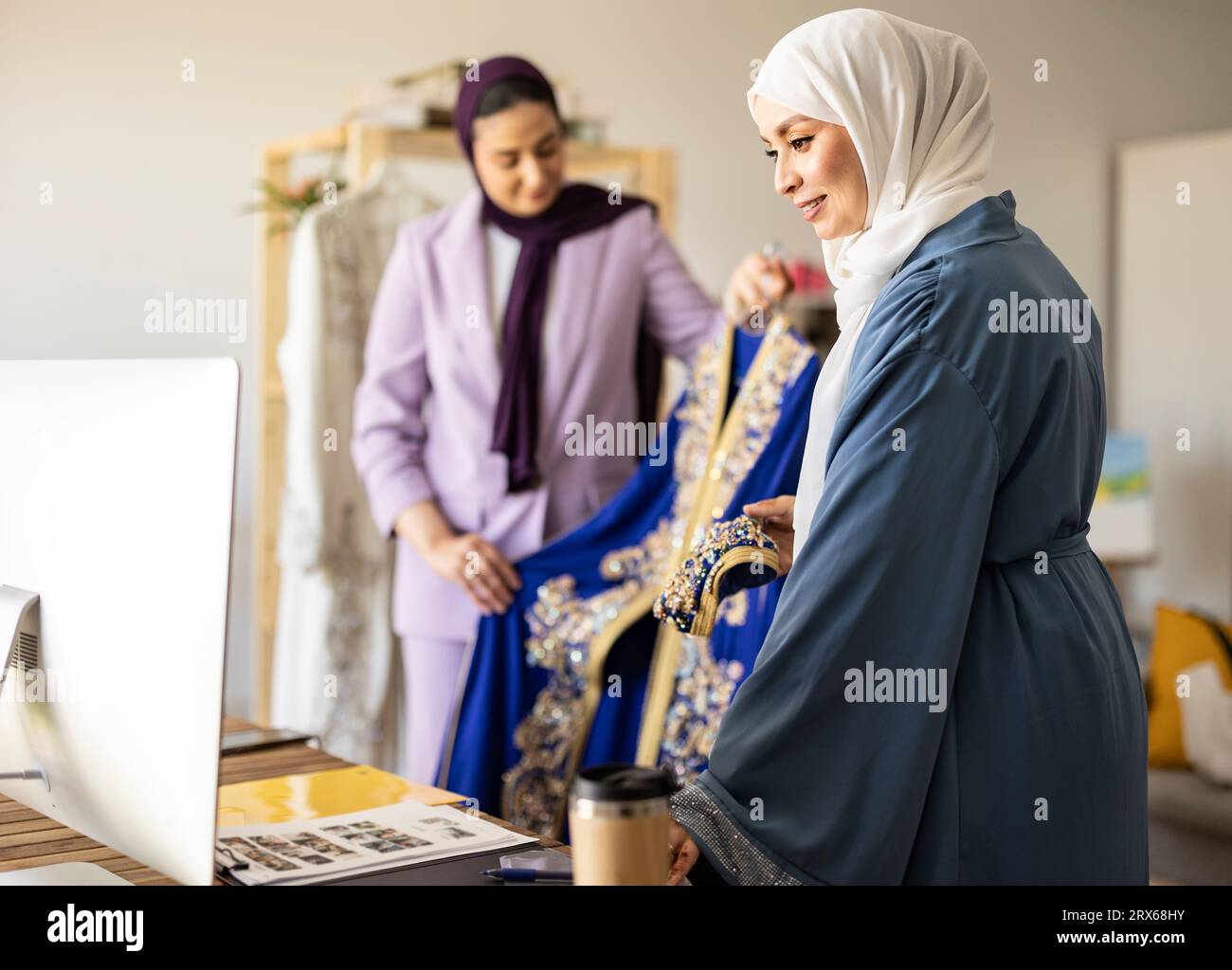 Happy fashion designers showing wedding dress on video call Stock Photo ...