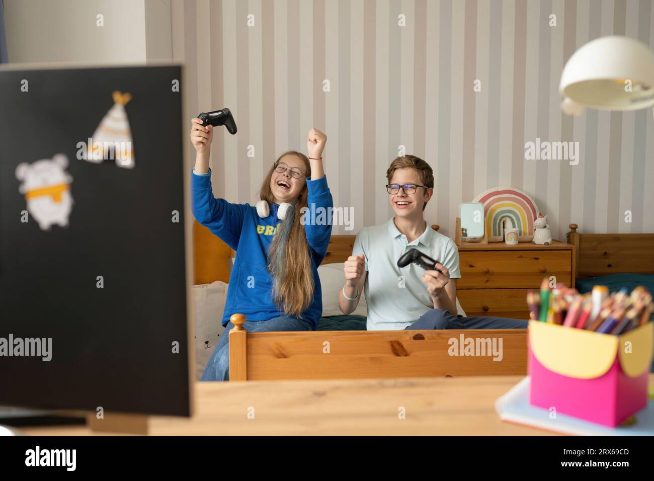 Happy friends with joysticks celebrates winning video game at home Stock Photo