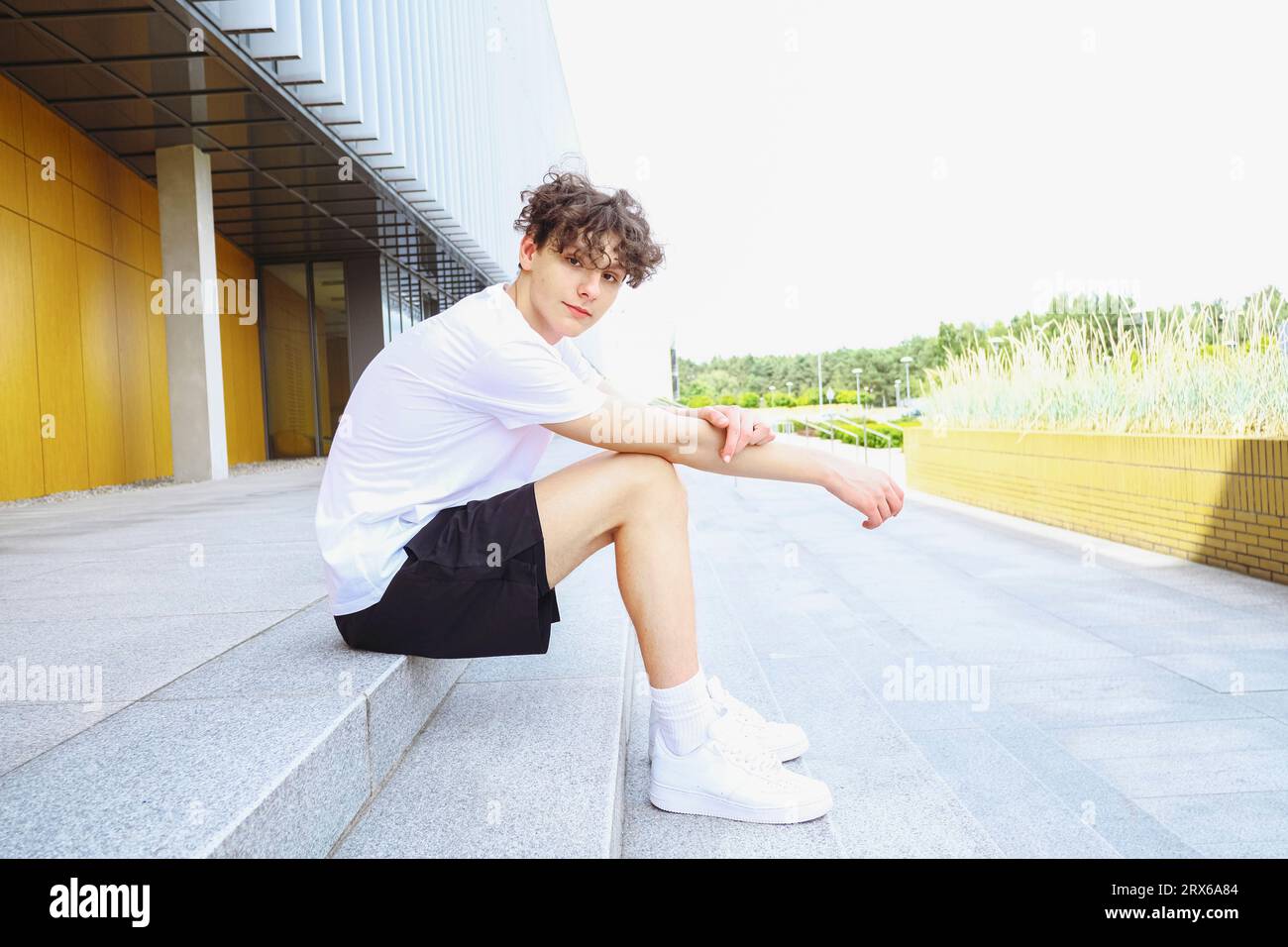 Smiling teenage boy sitting on steps Stock Photo - Alamy