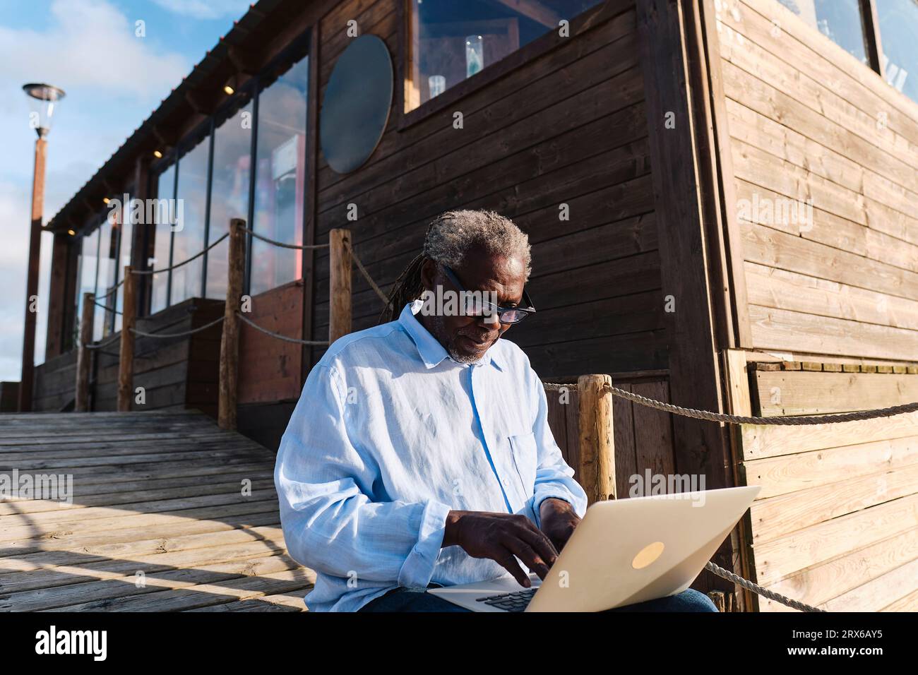 Engineer working on laptop in front of cafe Stock Photo