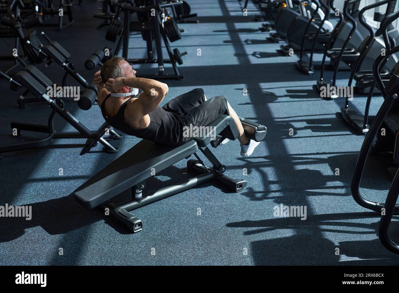 Strong man doing abdominal exercise in gym Stock Photo