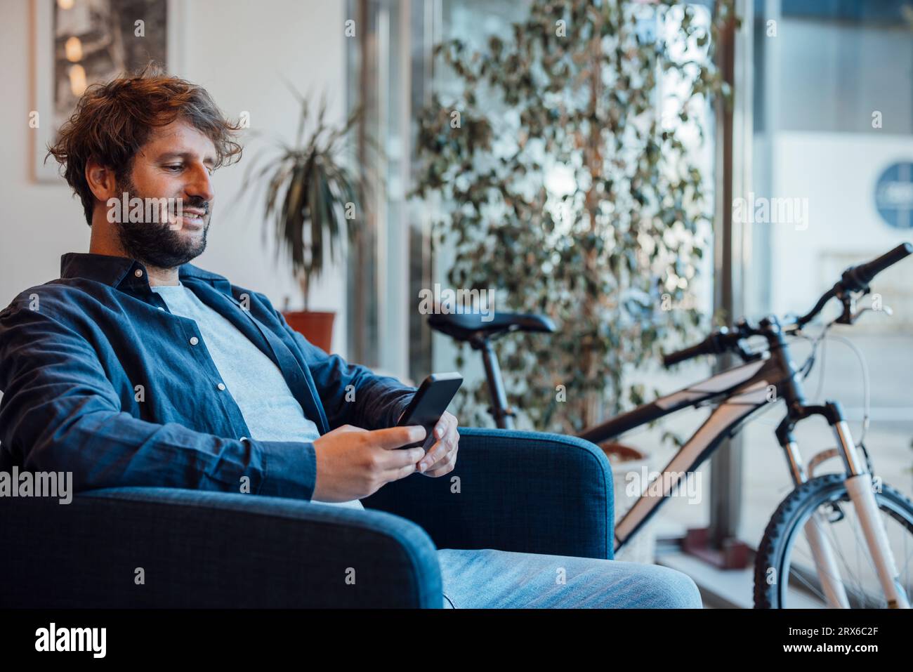 Happy businessman using smart phone in office Stock Photo