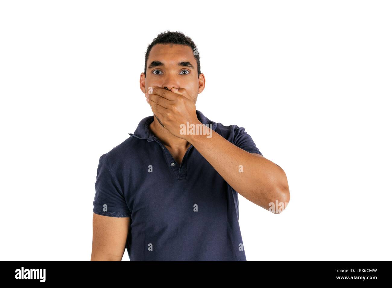 Man covering mouth with hand against white background Stock Photo