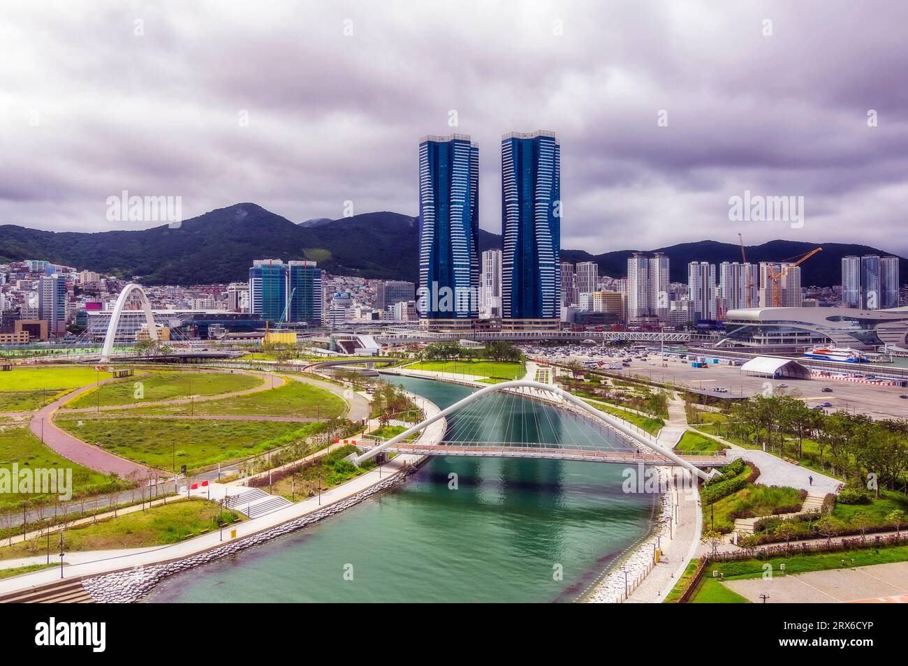 South Korea, Busan, Cloudy sky over bridge over river flowing through city park Stock Photo