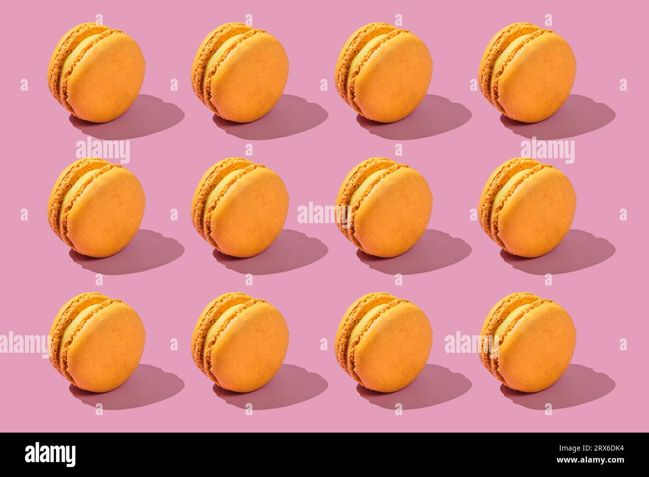 Yellow macaroons arranged on pink background Stock Photo
