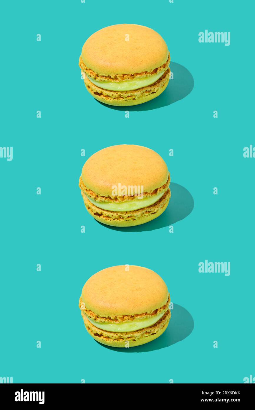 Yellow macaroons arranged in a row on colored background Stock Photo