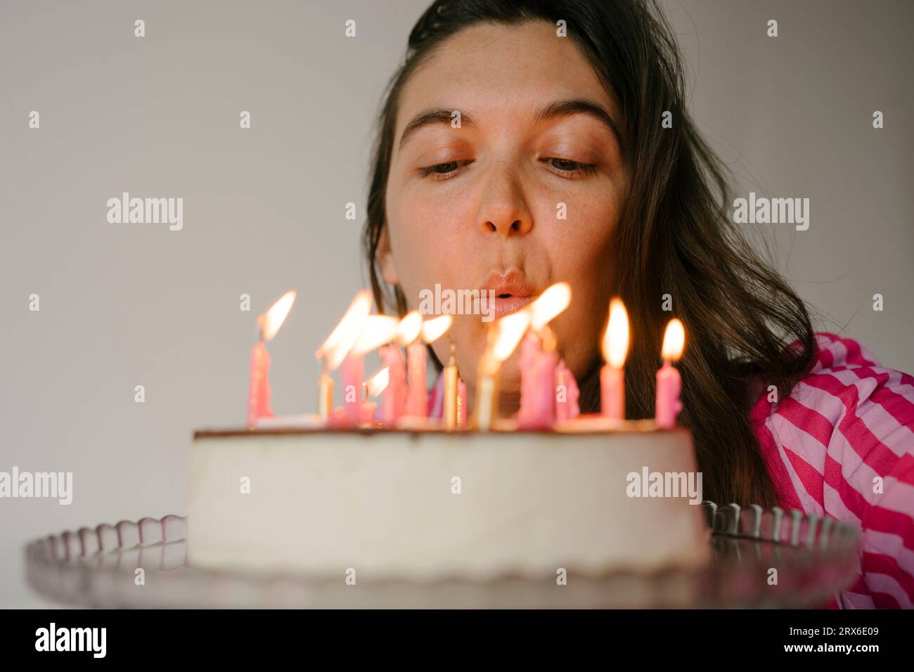Woman blowing candles on birthday cake Stock Photo