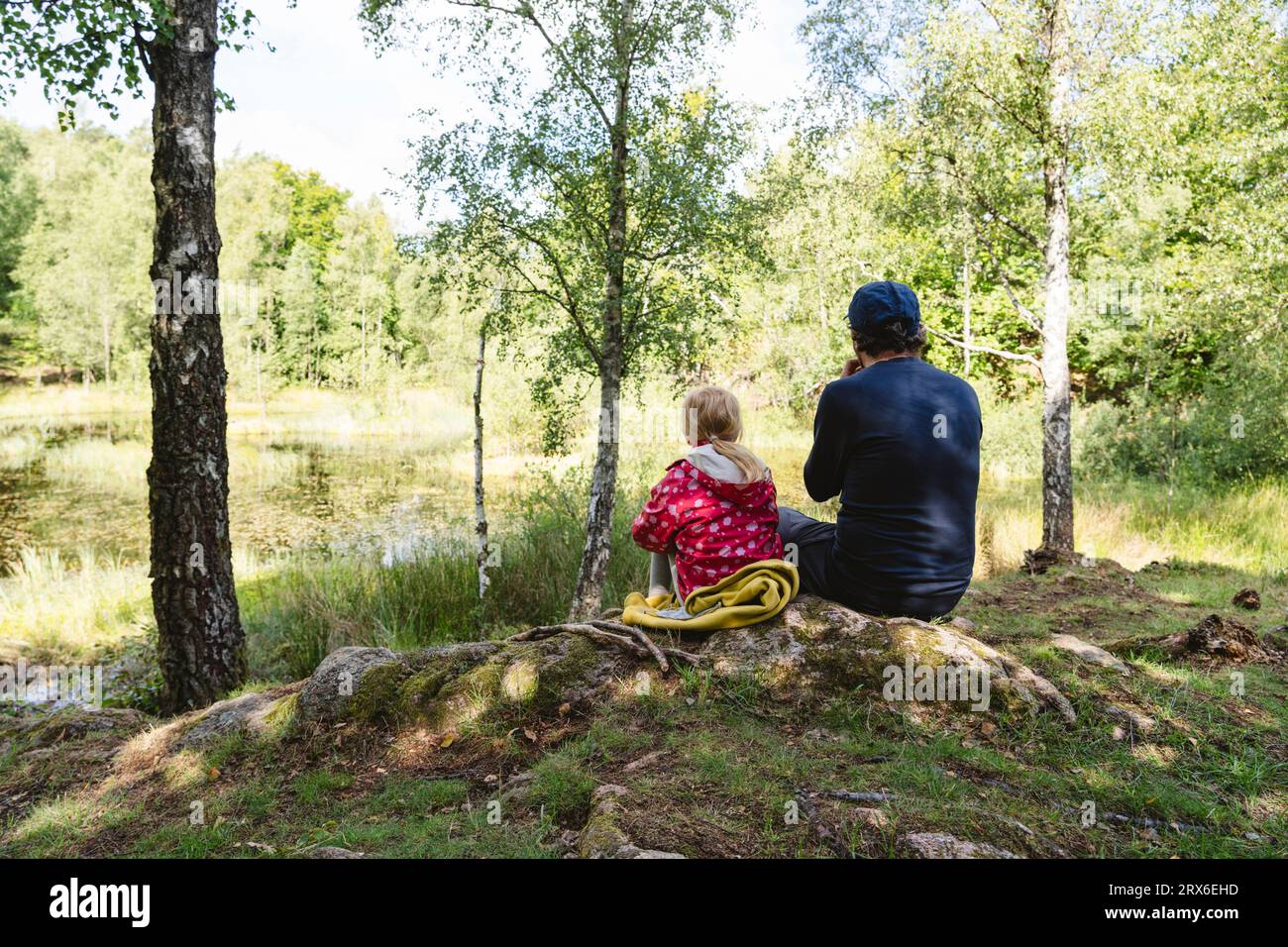 Father and daughter sitting together in forest Stock Photo - Alamy