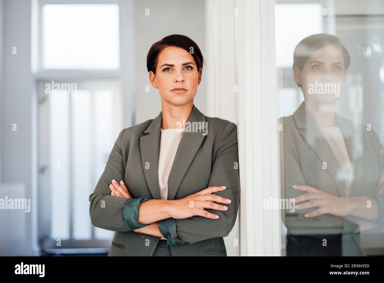 Confident businesswoman in blazer standing at office Stock Photo