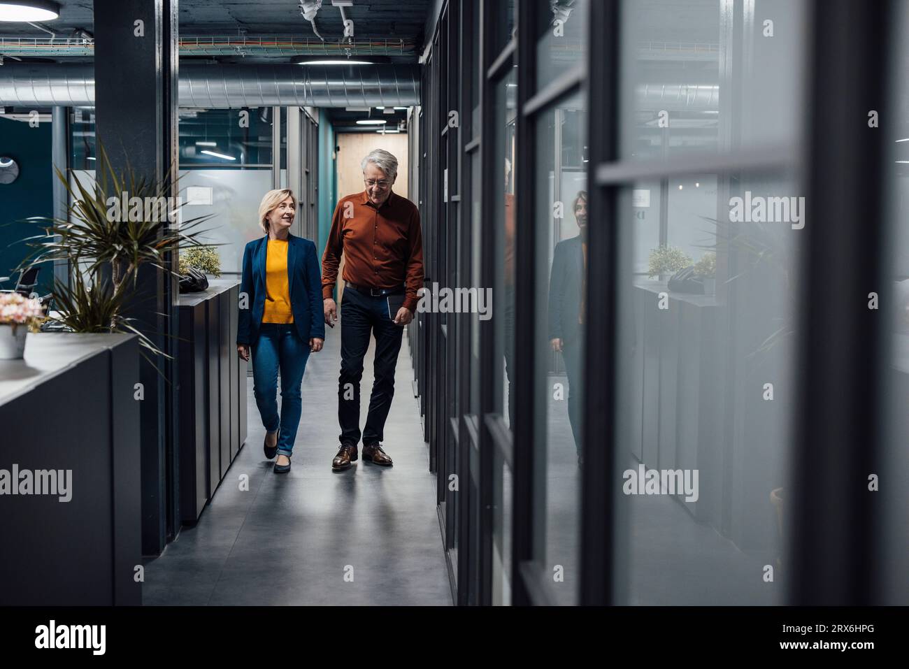Business colleagues walking and discussing strategy in corridor at office Stock Photo