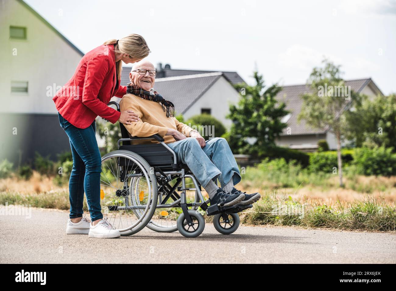 Woman talking with elderly man sitting in wheelchair Stock Photo