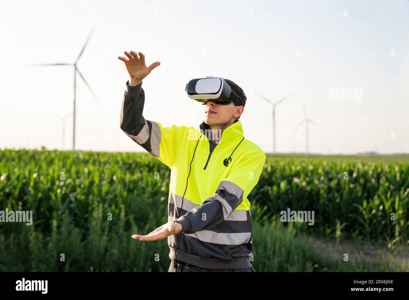Engineer gesturing with virtual reality simulator in field Stock Photo