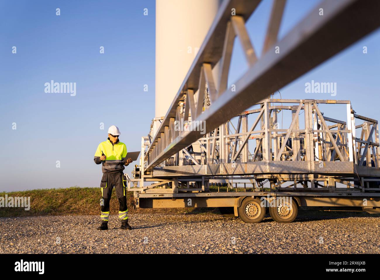 Engineer using laptop by wind turbine maintenance machine Stock Photo