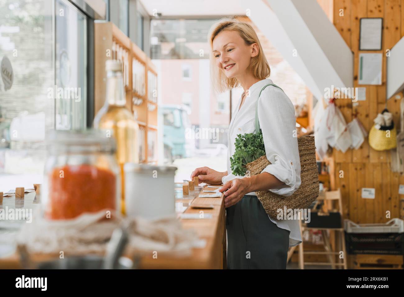 Happy blond woman shopping groceries at store Stock Photo