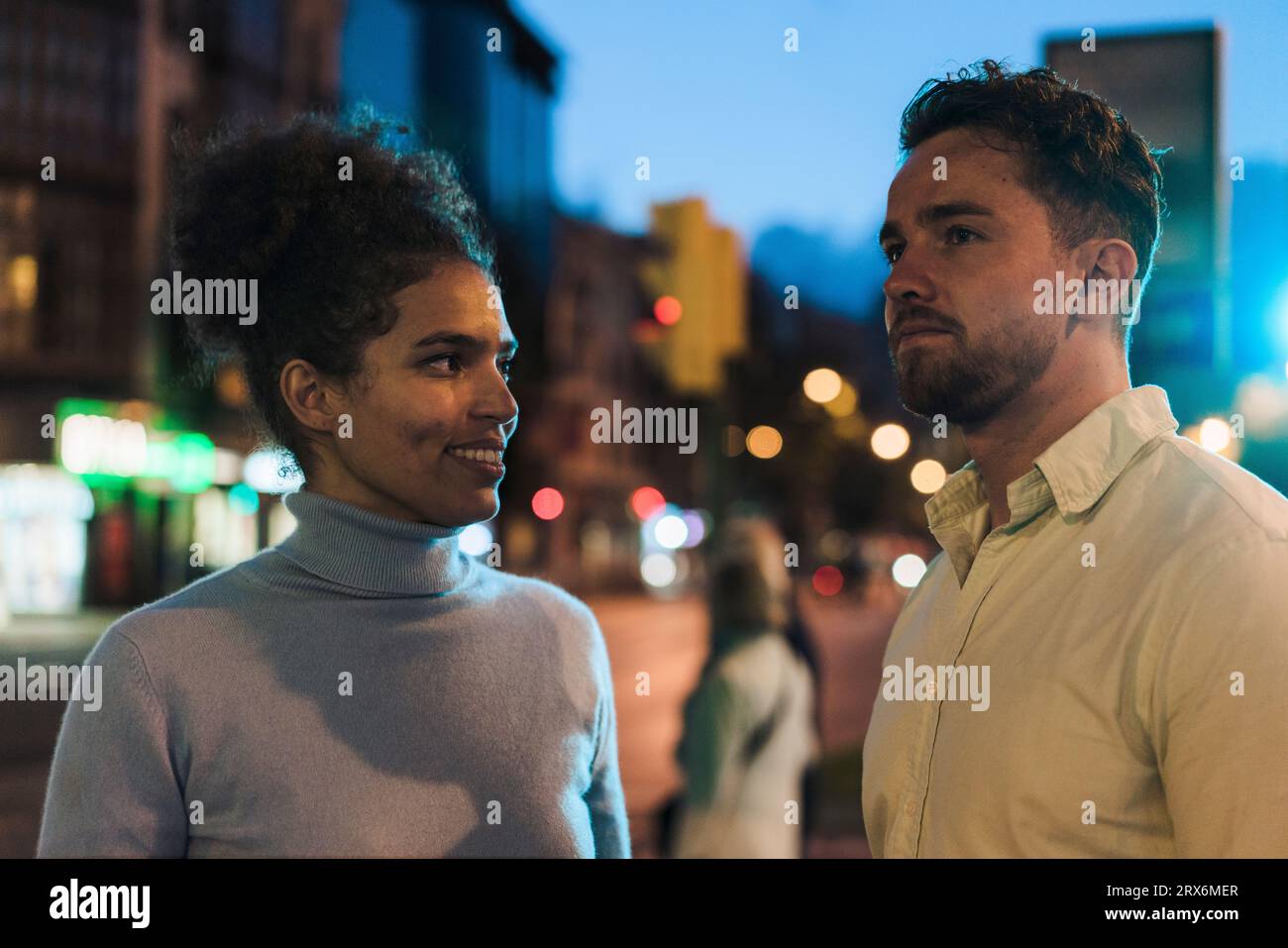 Smiling young woman looking at man Stock Photo