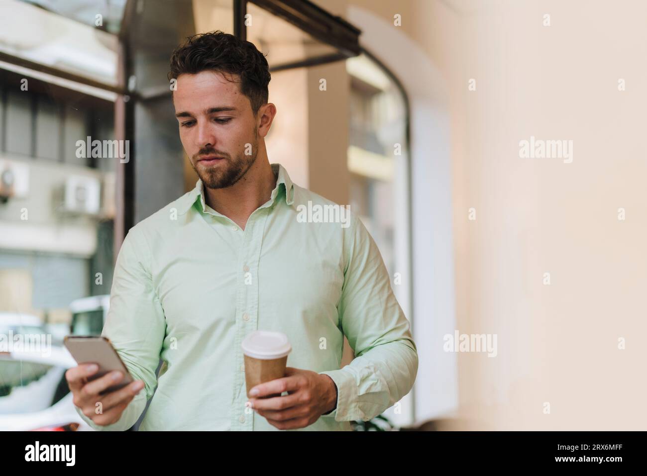 Young businessman using smart phone in cafe Stock Photo